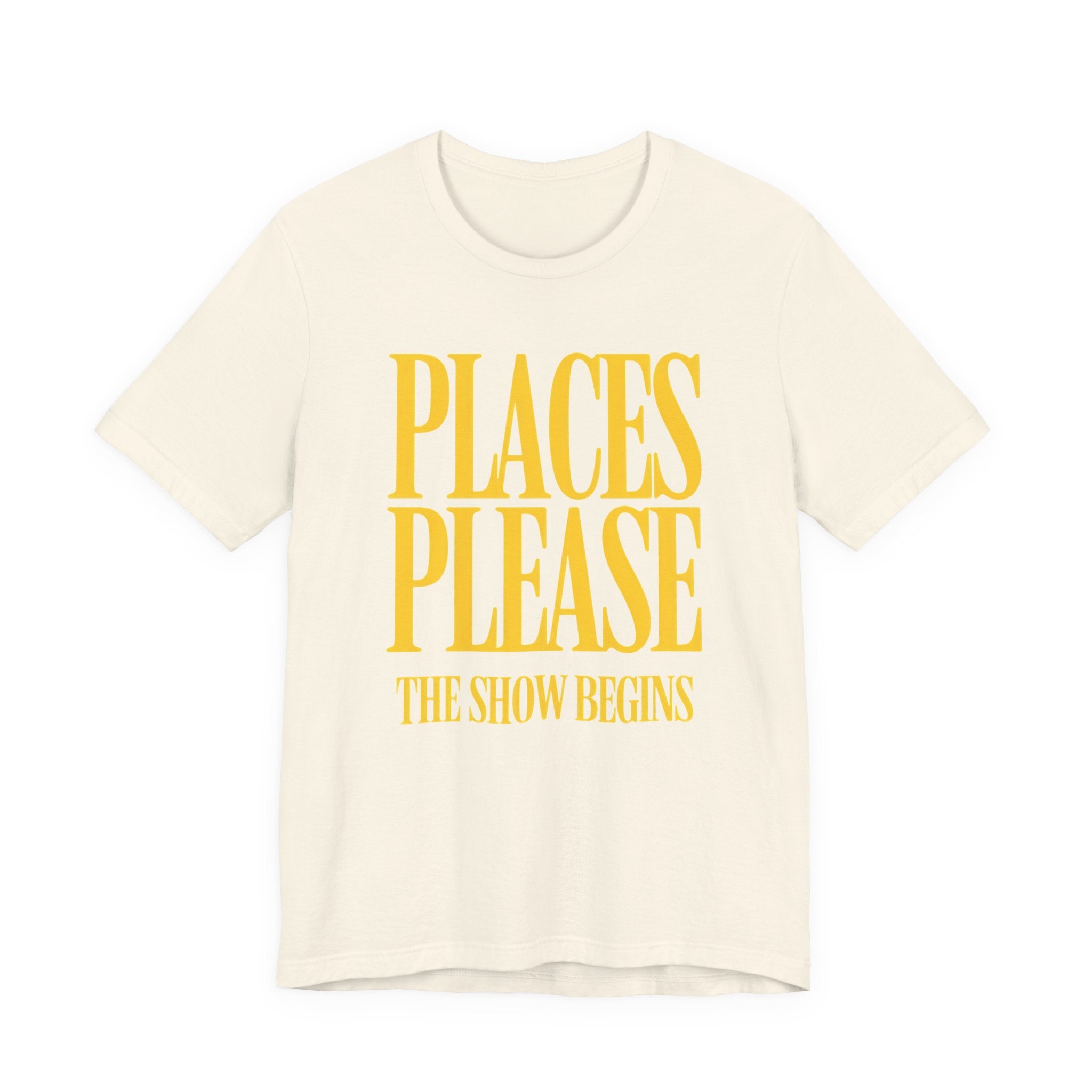 Beige t-shirt with yellow text 'PLACES PLEASE THE SHOW BEGINS' on a white background