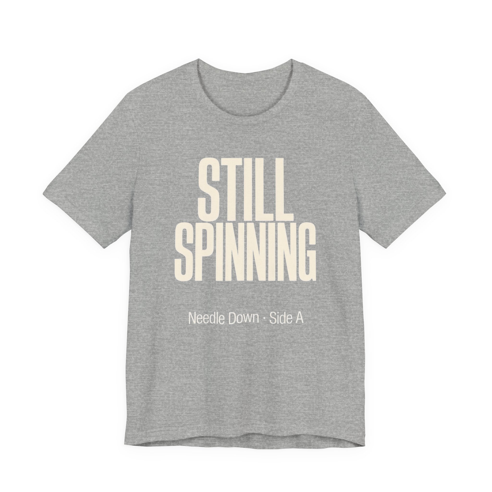 Gray t-shirt with 'STILL SPINNING' text on a white background