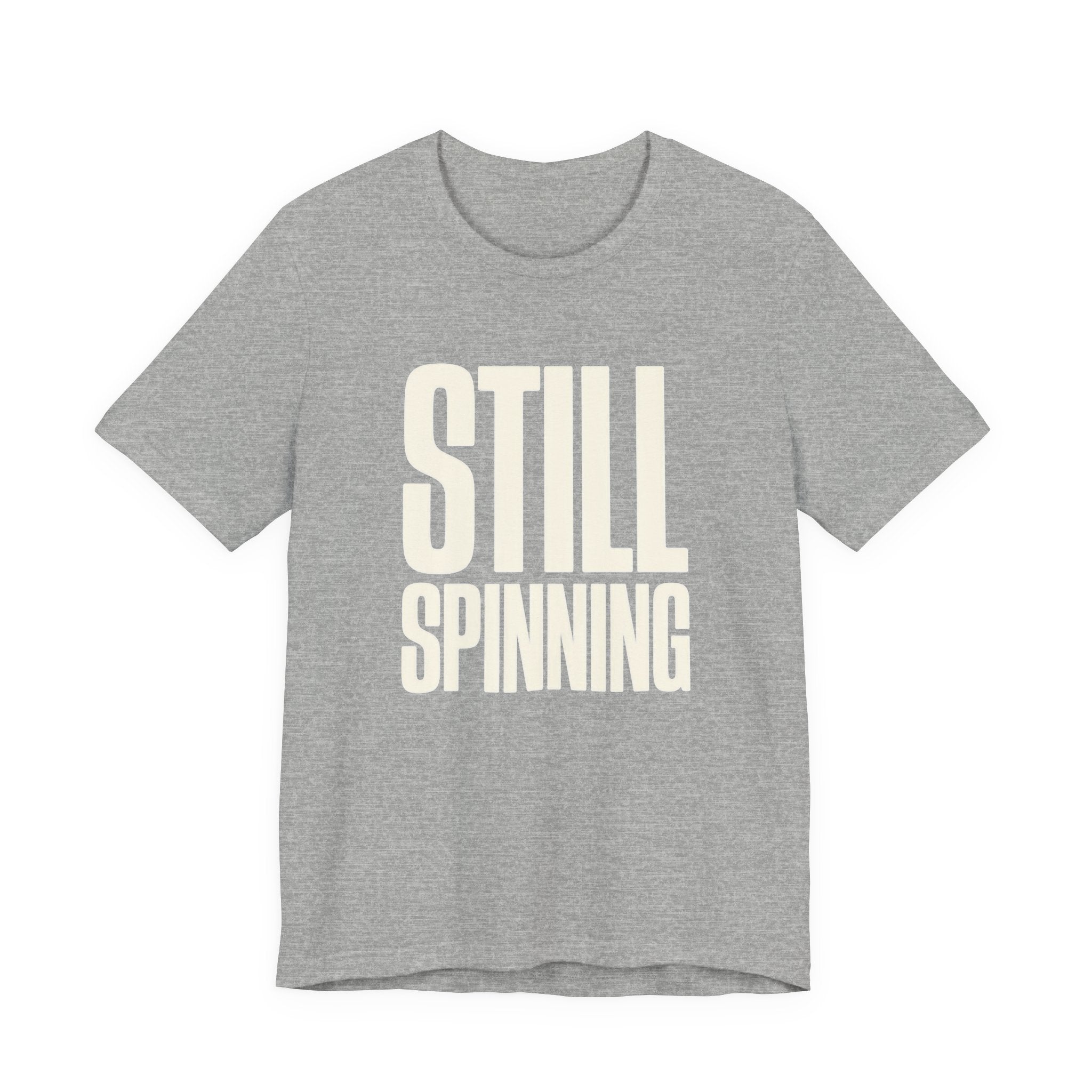 Gray t-shirt with 'STILL SPINNING' text on a white background
