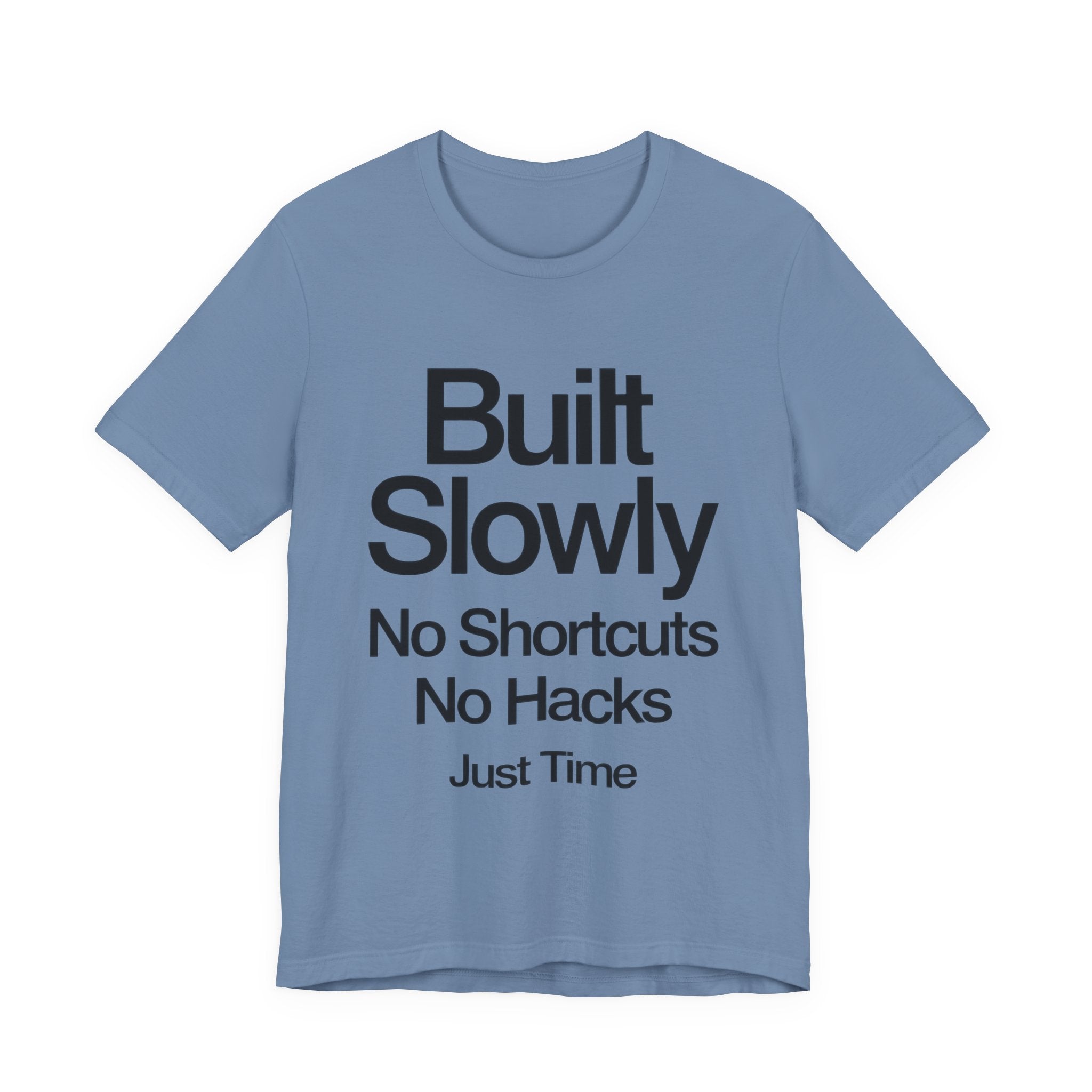 Blue t-shirt with black text 'Built Slowly No Shortcuts No Hacks Just Time' on a white background