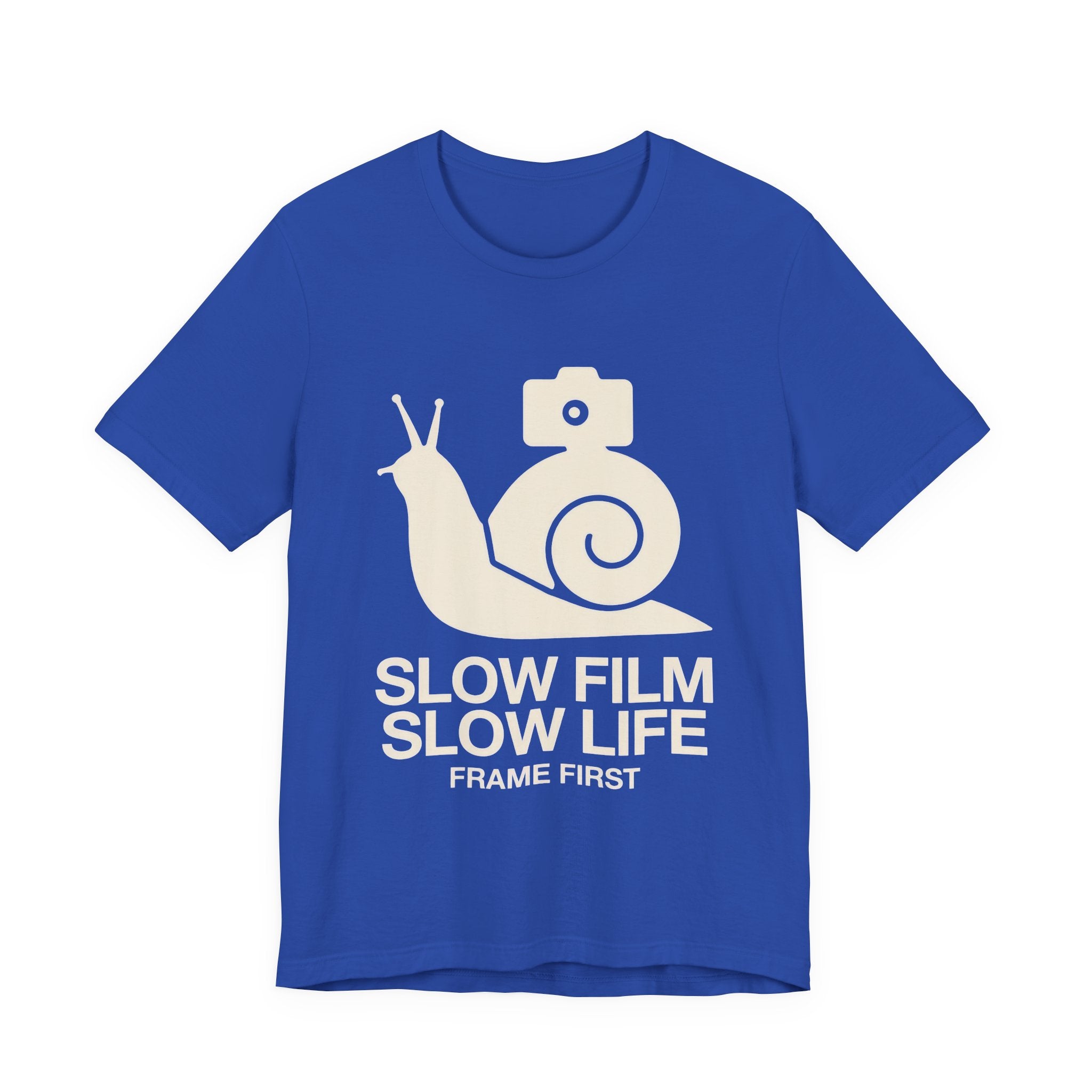 Blue t-shirt with a snail and camera graphic and text 'Slow Film Slow Life Frame First' on a white background