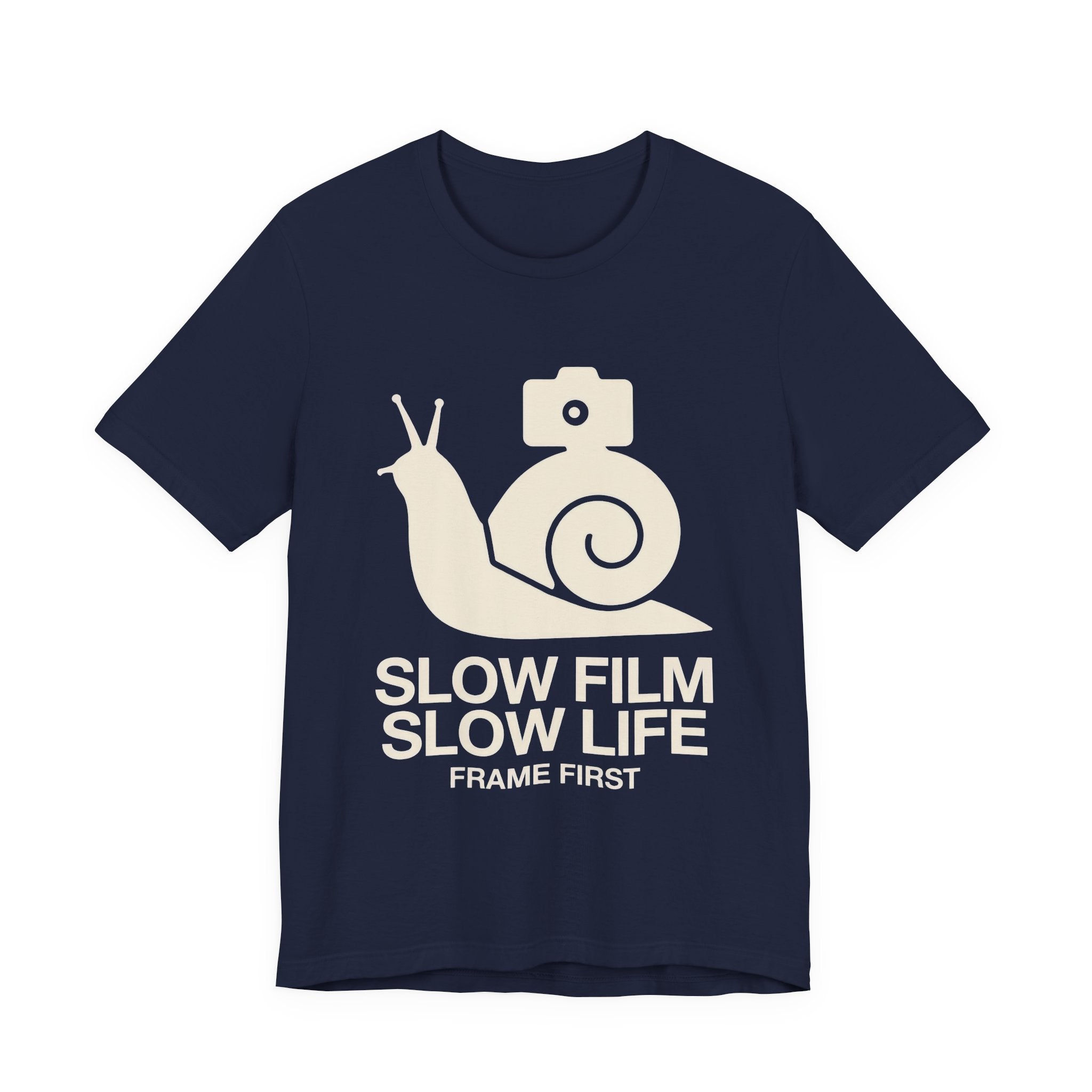 Navy blue t-shirt with a white snail and camera graphic and text 'Slow Film Slow Life Frame First' on a white background.