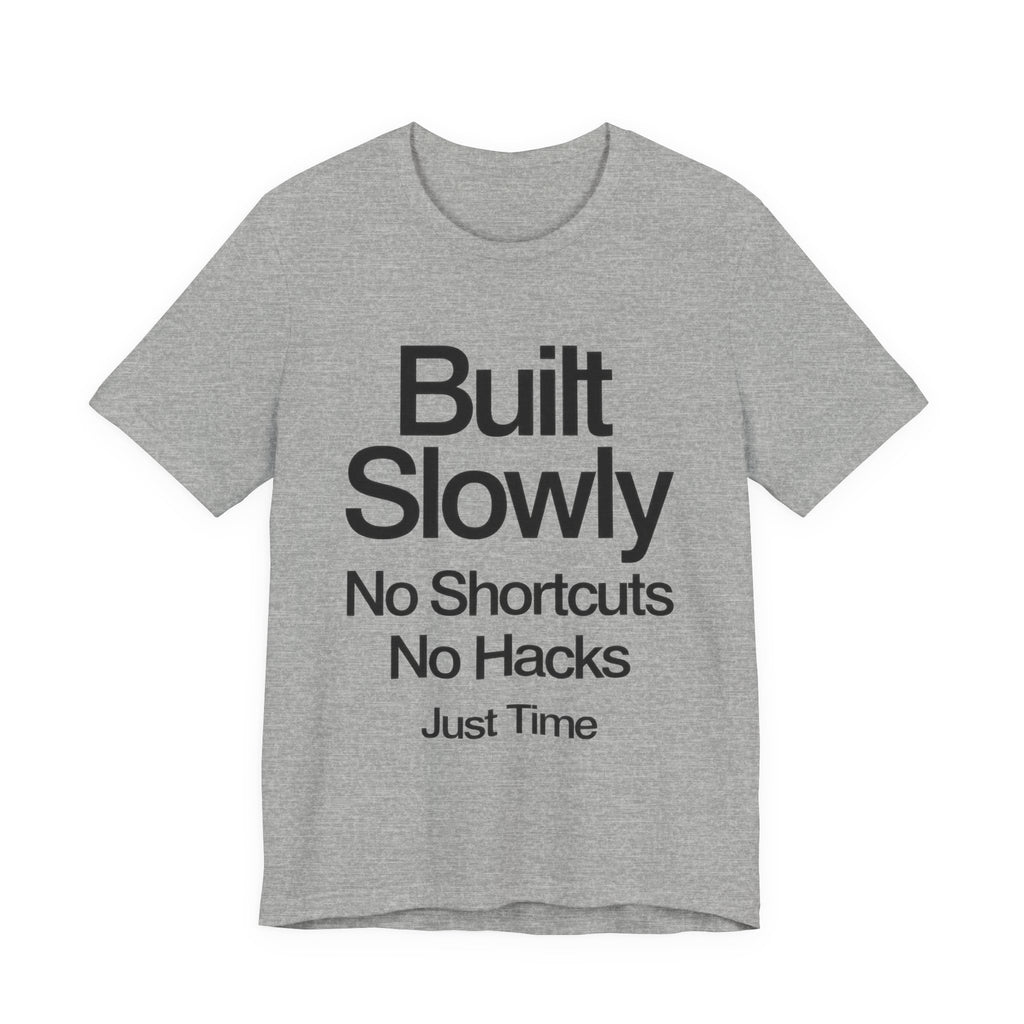 Gray t-shirt with black text 'Built Slowly No Shortcuts No Hacks Just Time' on a white background