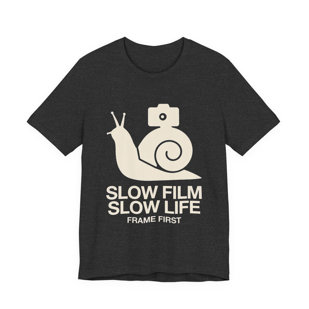 Black t-shirt with a snail and camera graphic and text 'Slow Film Slow Life Frame First' on a white background