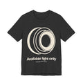 Dark gray t-shirt with white camera lens graphic and text 'Available light only' on a white background