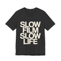 Black t-shirt with 'SLOW FILM SLOW LIFE' text on a white background