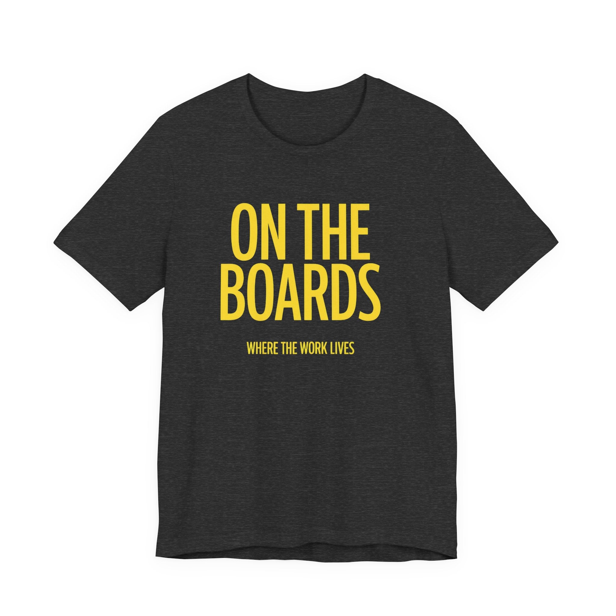 Black t-shirt with yellow text 'ON THE BOARDS WHERE THE WORK LIVES' on a white background