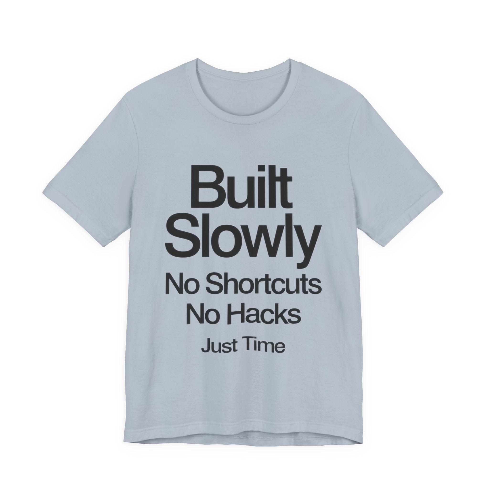 Light blue t-shirt with black text 'Built Slowly No Shortcuts No Hacks Just Time' on a white background