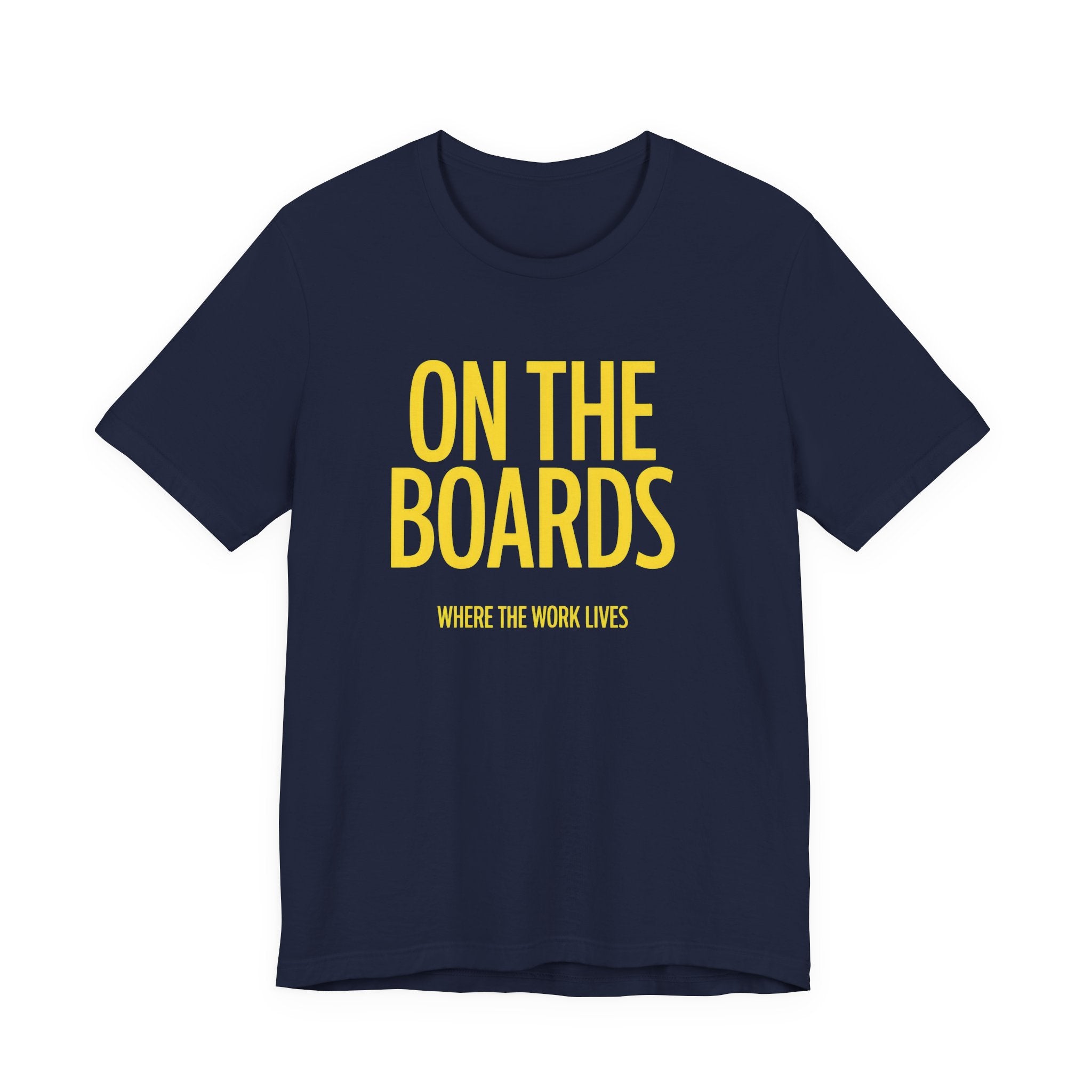 Navy blue t-shirt with yellow text 'ON THE BOARDS WHERE THE WORK LIVES' on a white background