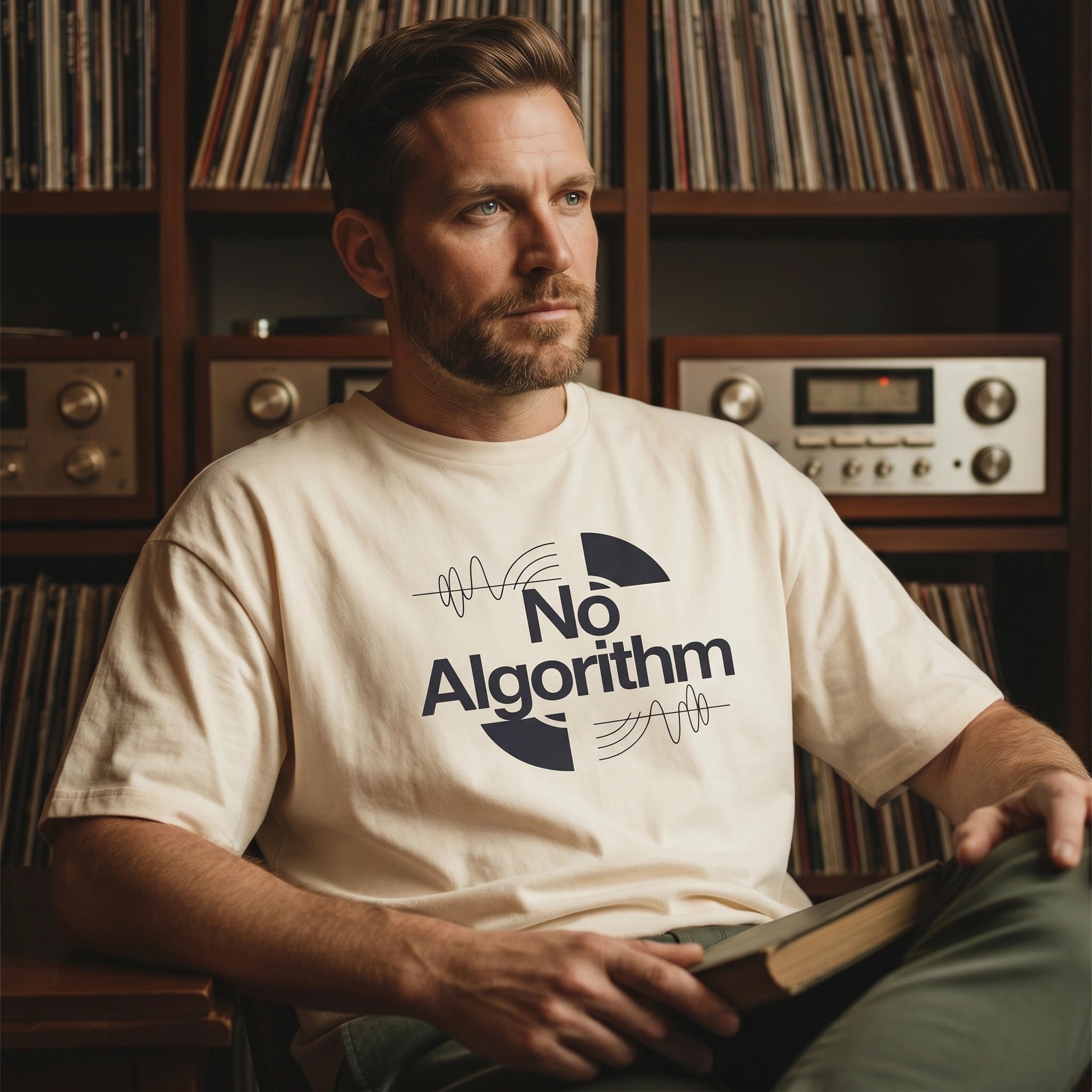 Man wearing a t-shirt with 'No Algorithm' design, sitting in front of a record player and records.