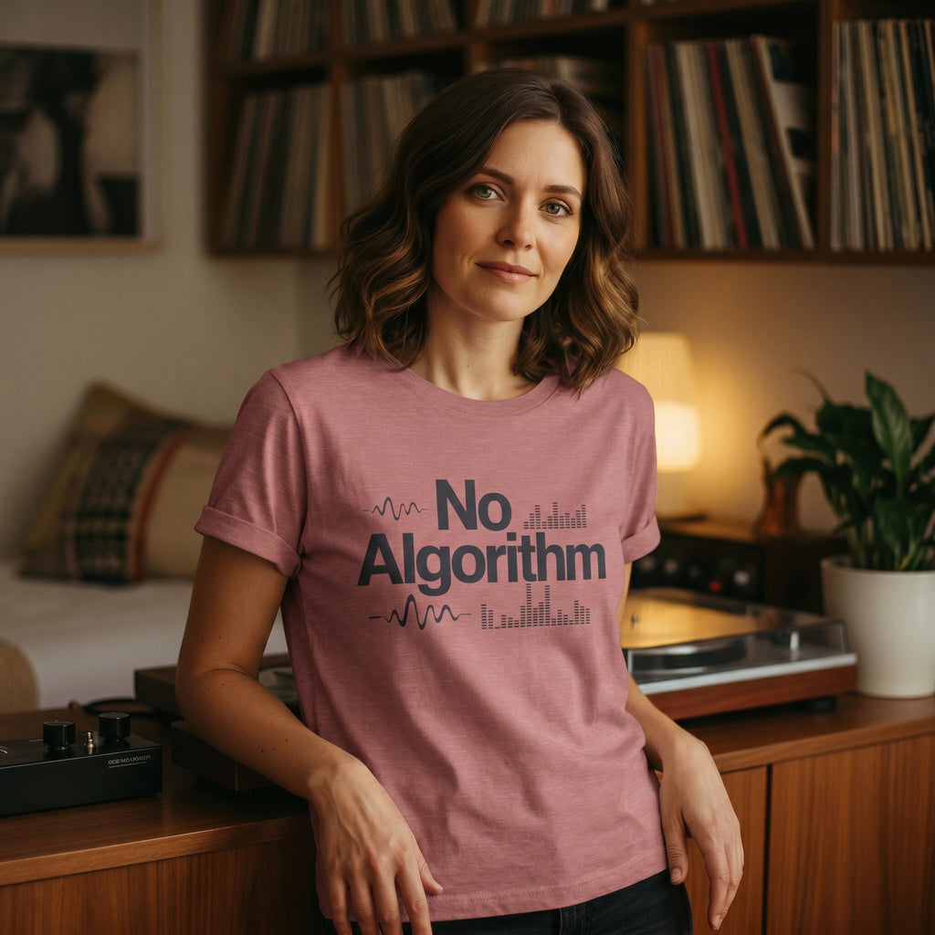 Woman wearing a pink t-shirt with 'No Algorithm' text in a cozy room.