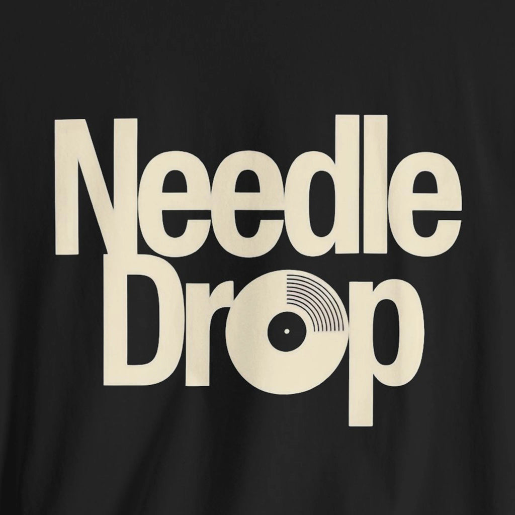 Black t-shirt with 'Needle Drop' text in beige on a black background