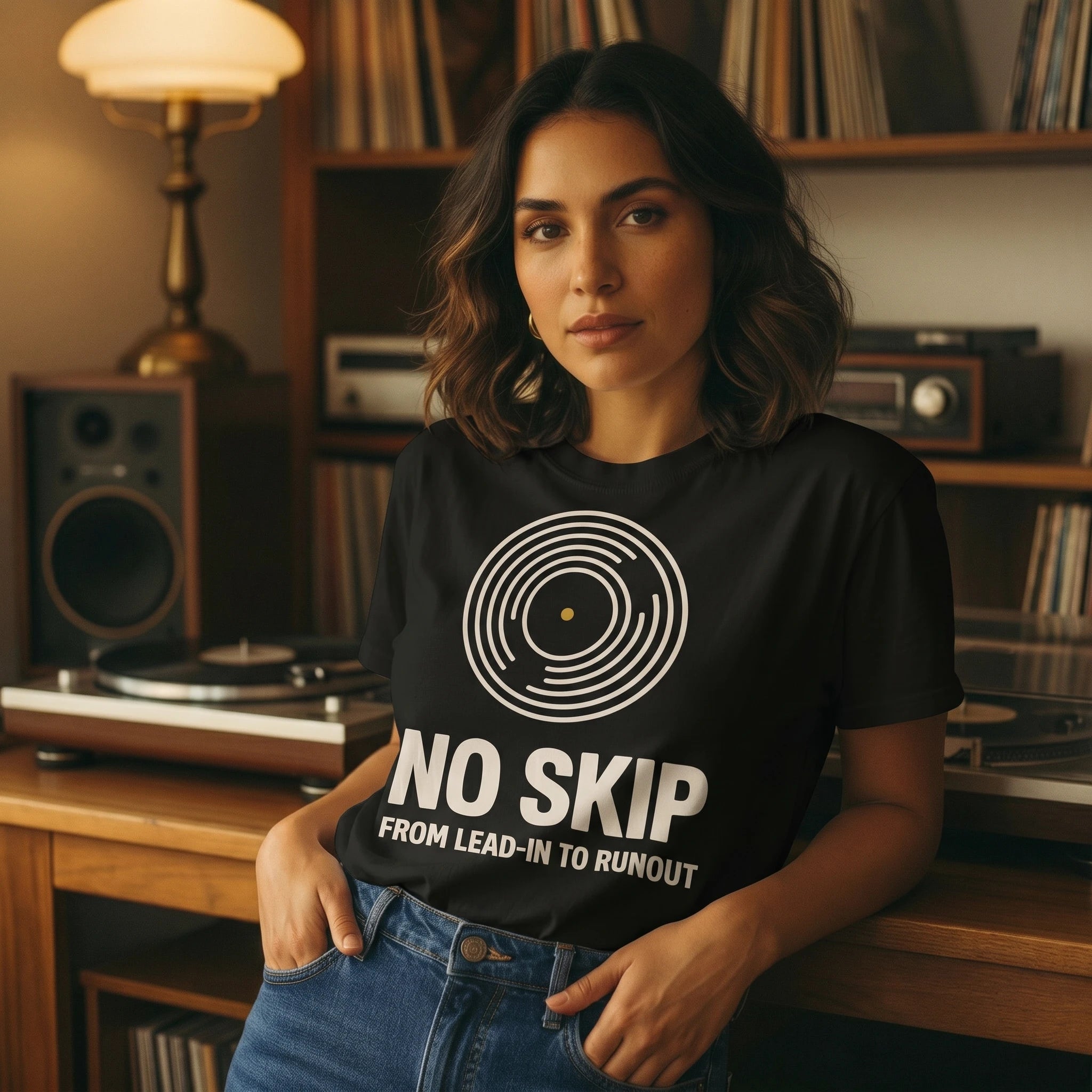 Woman wearing a black t-shirt with 'No Skip' design in a record player room.