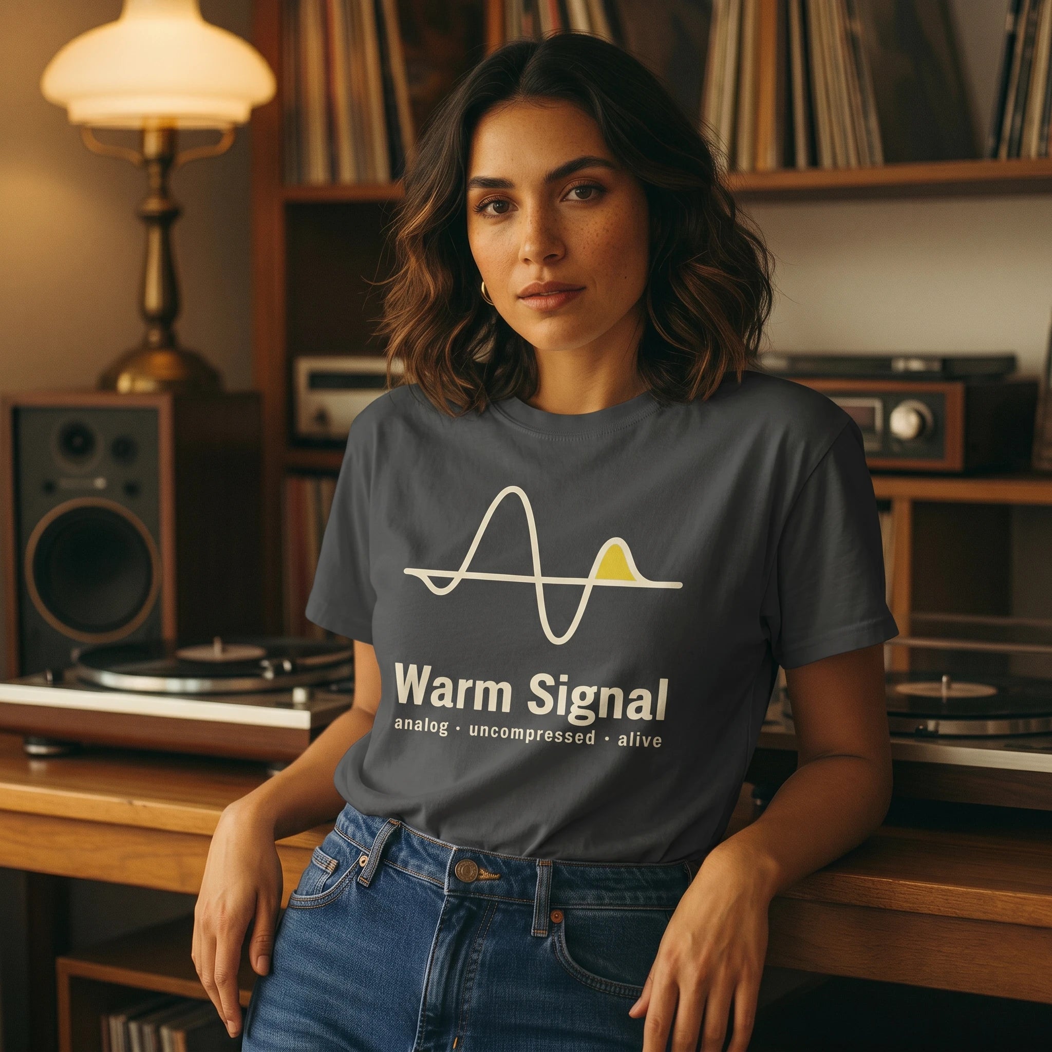 Woman wearing a 'Warm Signal' t-shirt in a room with vintage record players and speakers.