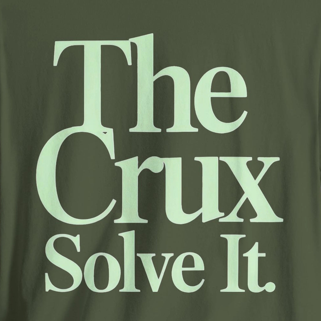 Green t-shirt with 'The Crux Solve It' text in light green.