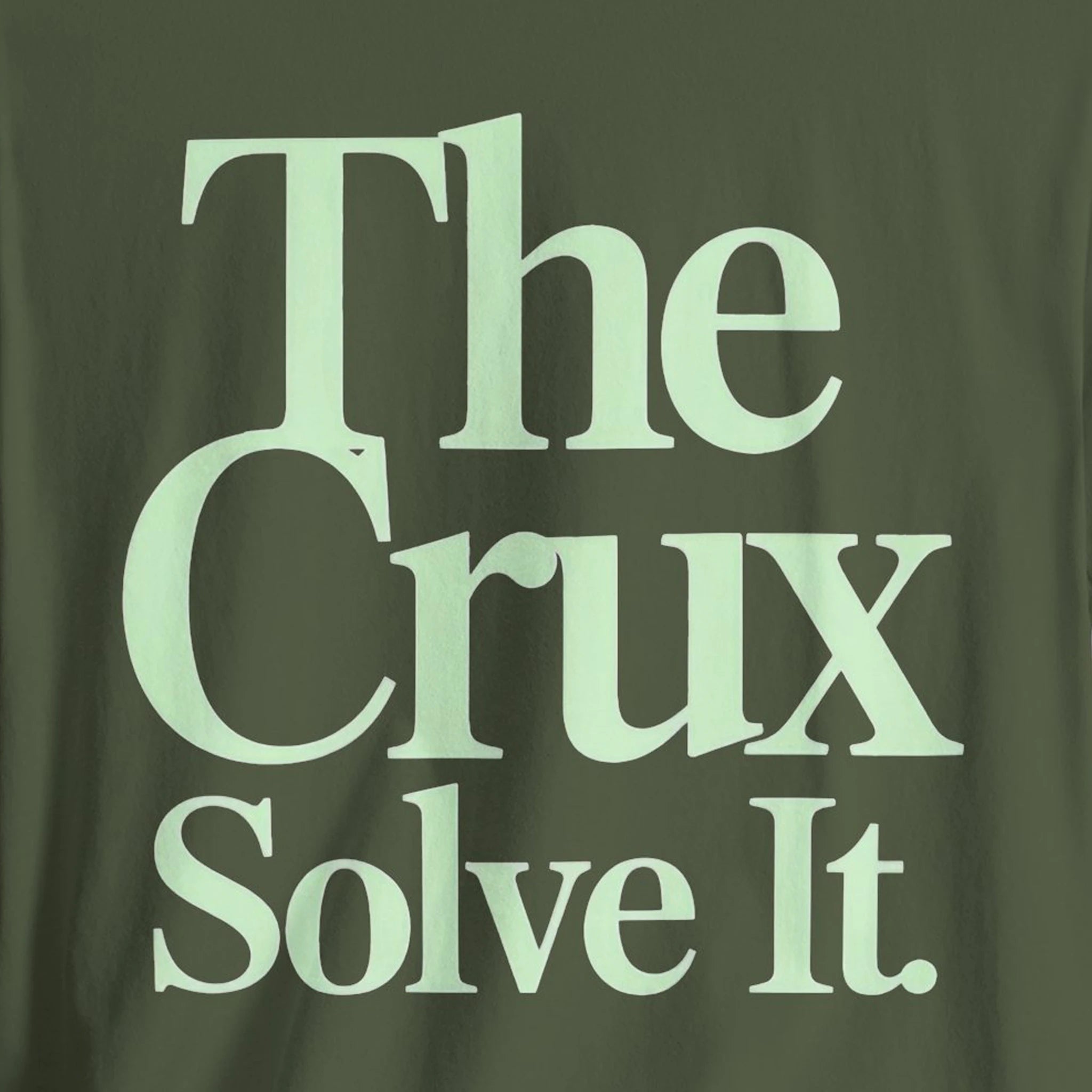 Green t-shirt with 'The Crux Solve It' text in light green.
