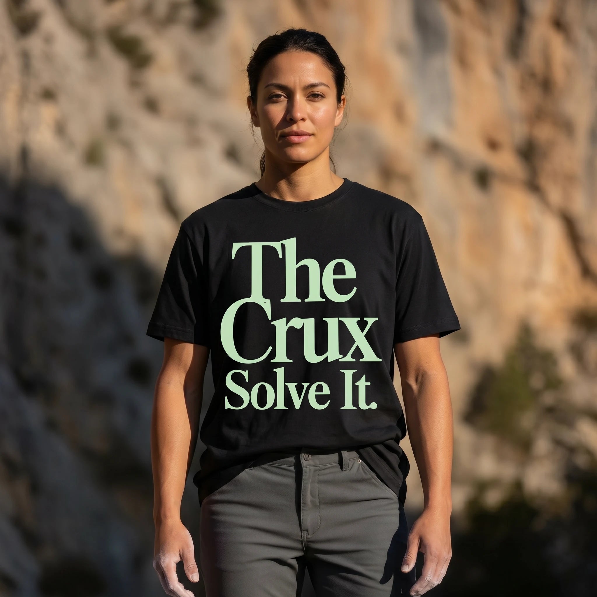 Person wearing a black t-shirt with 'The Crux Solve It' text against a natural background