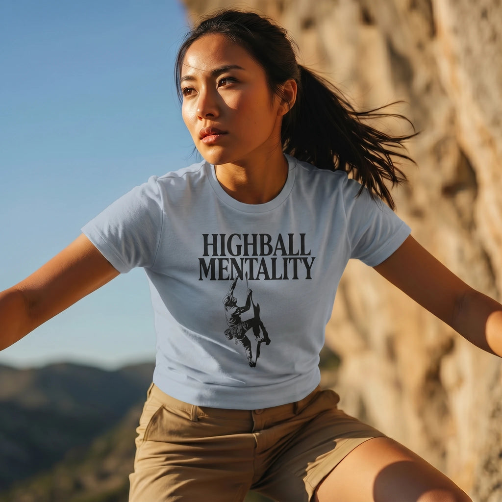 Woman wearing a 'Highball Mentality' t-shirt in a mountainous landscape