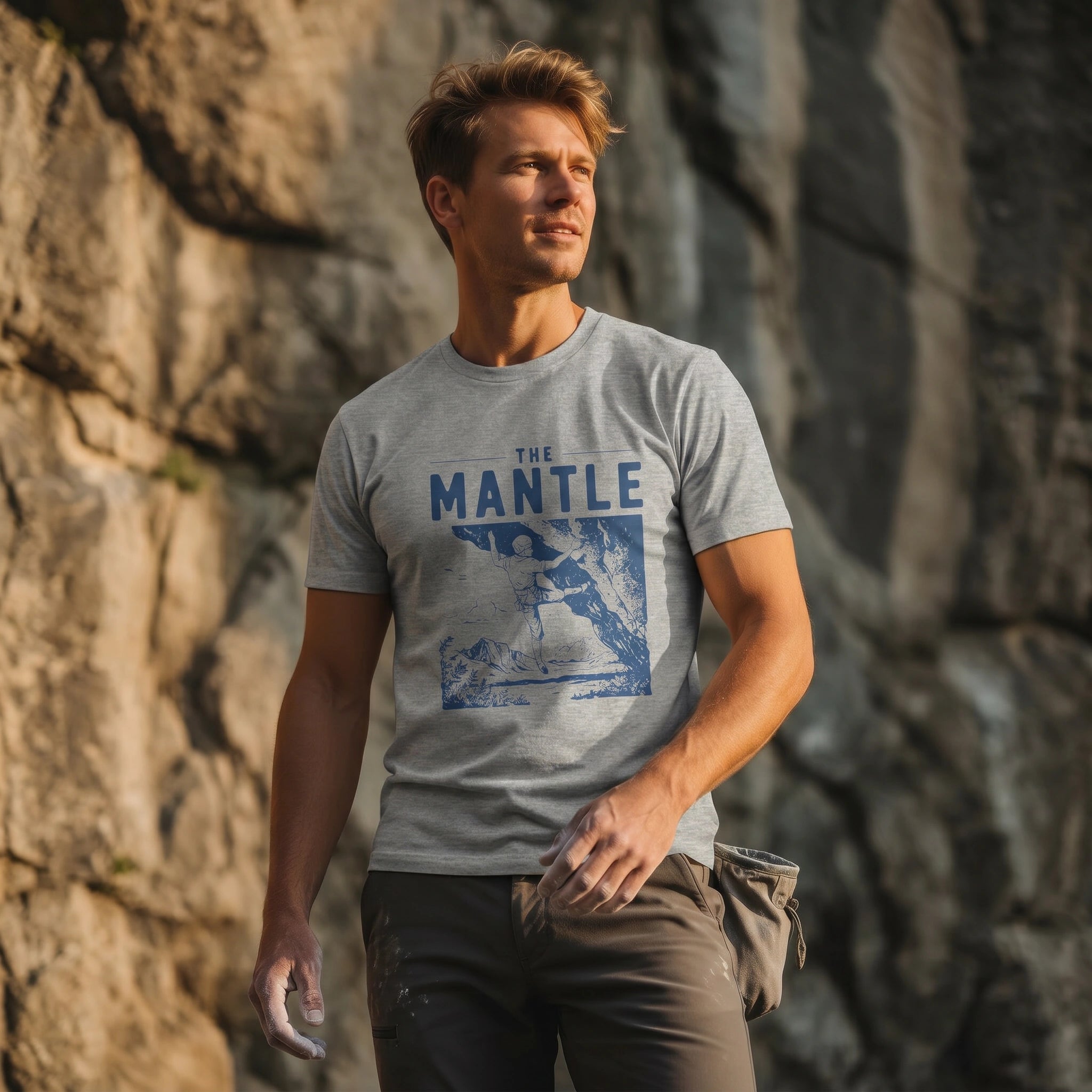Man wearing a t-shirt with 'The Mantle' design standing against a rocky background