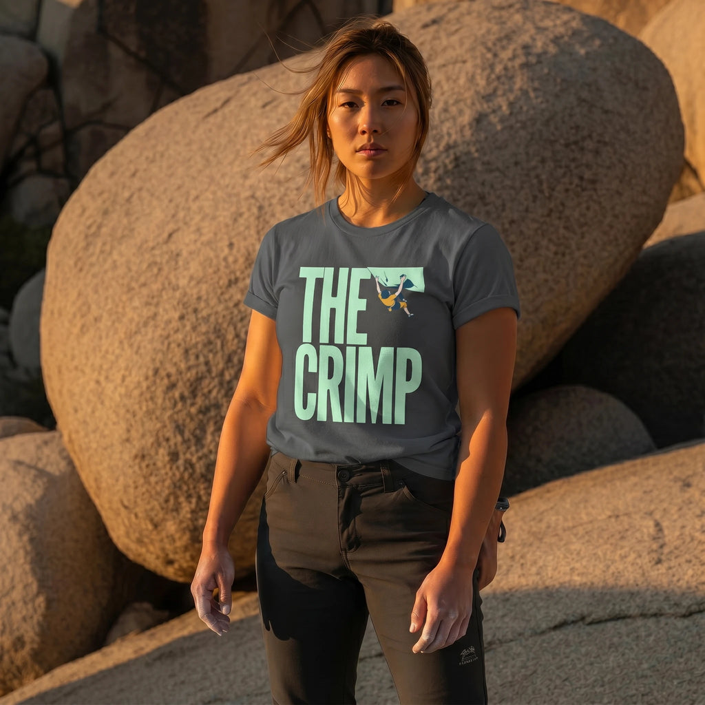 Person wearing a t-shirt with 'THE CRIMP' text standing among large rocks.