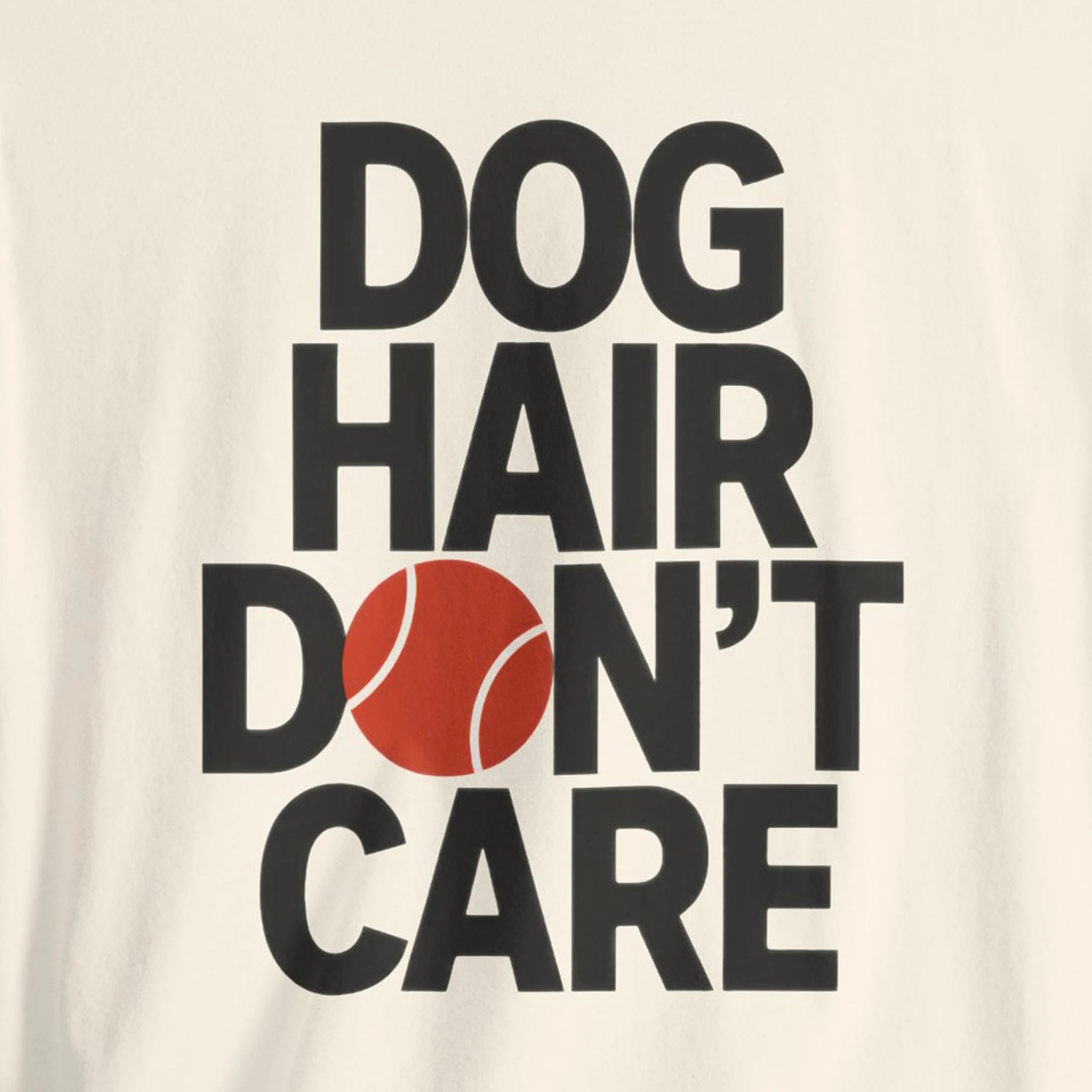 T-shirt with 'Dog Hair Don't Care' text and tennis ball graphic on a beige background