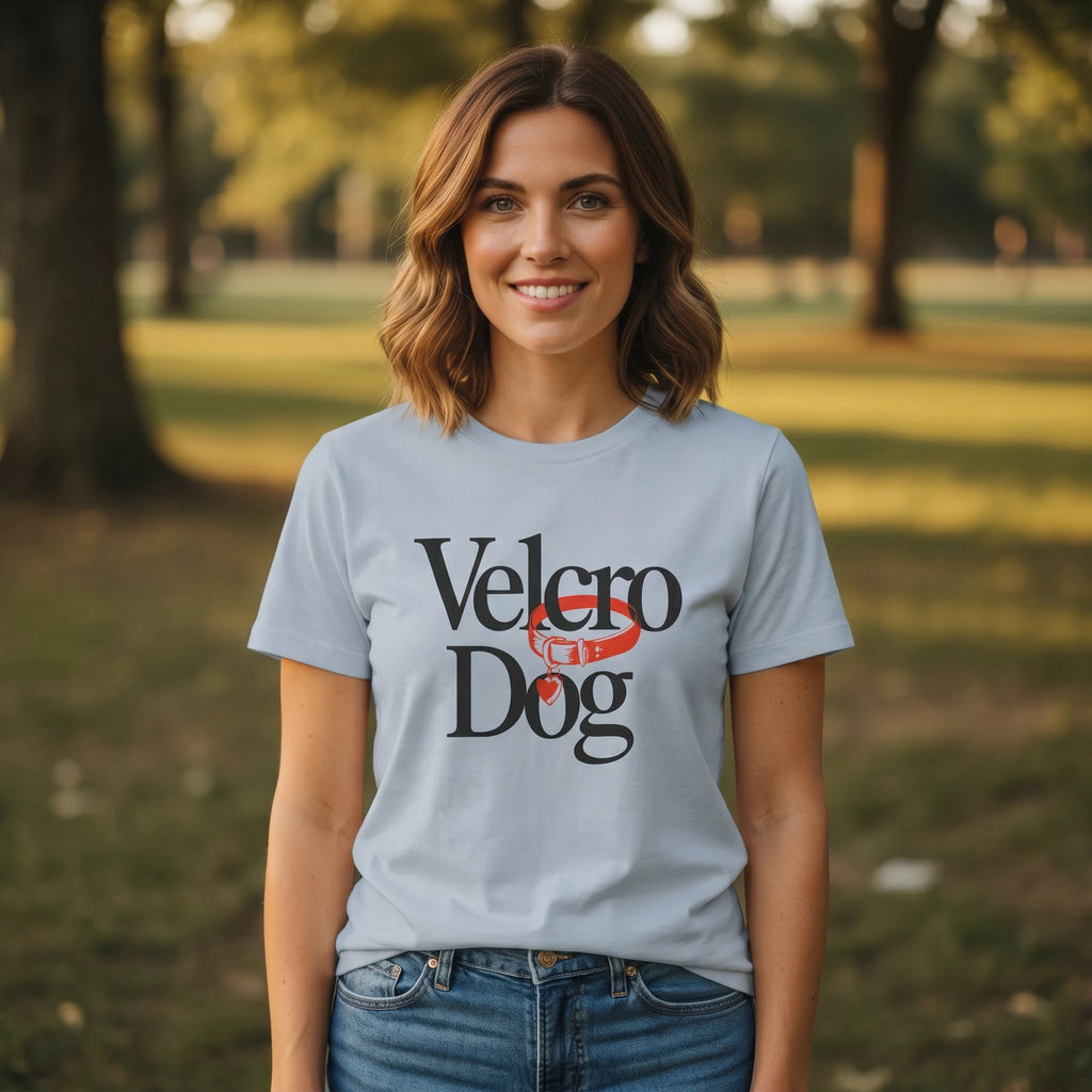 Woman wearing a light blue t-shirt with 'Velcro Dog' text in a park setting
