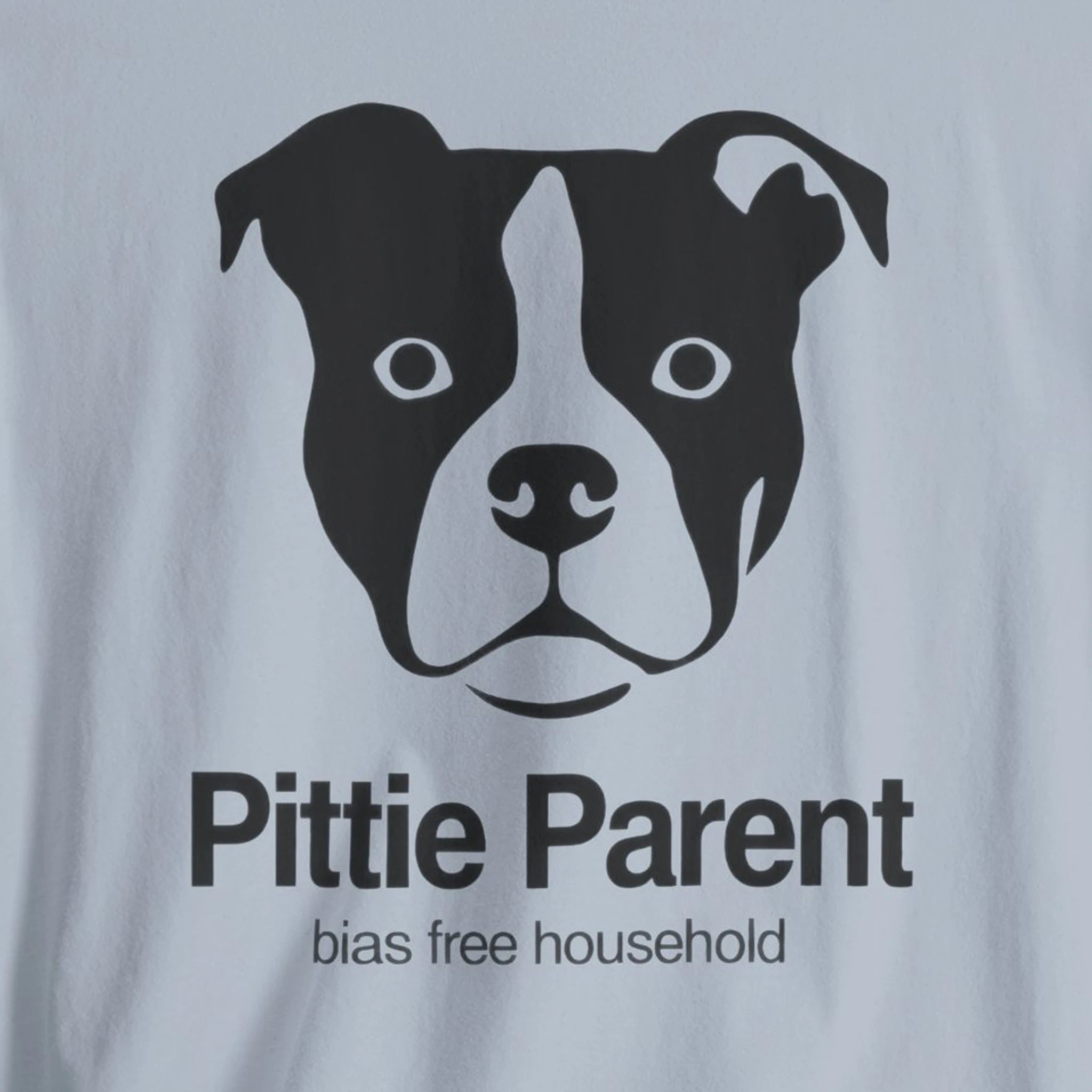 T-shirt with a dog face graphic and 'Pittie Parent bias free household' text on a light gray background