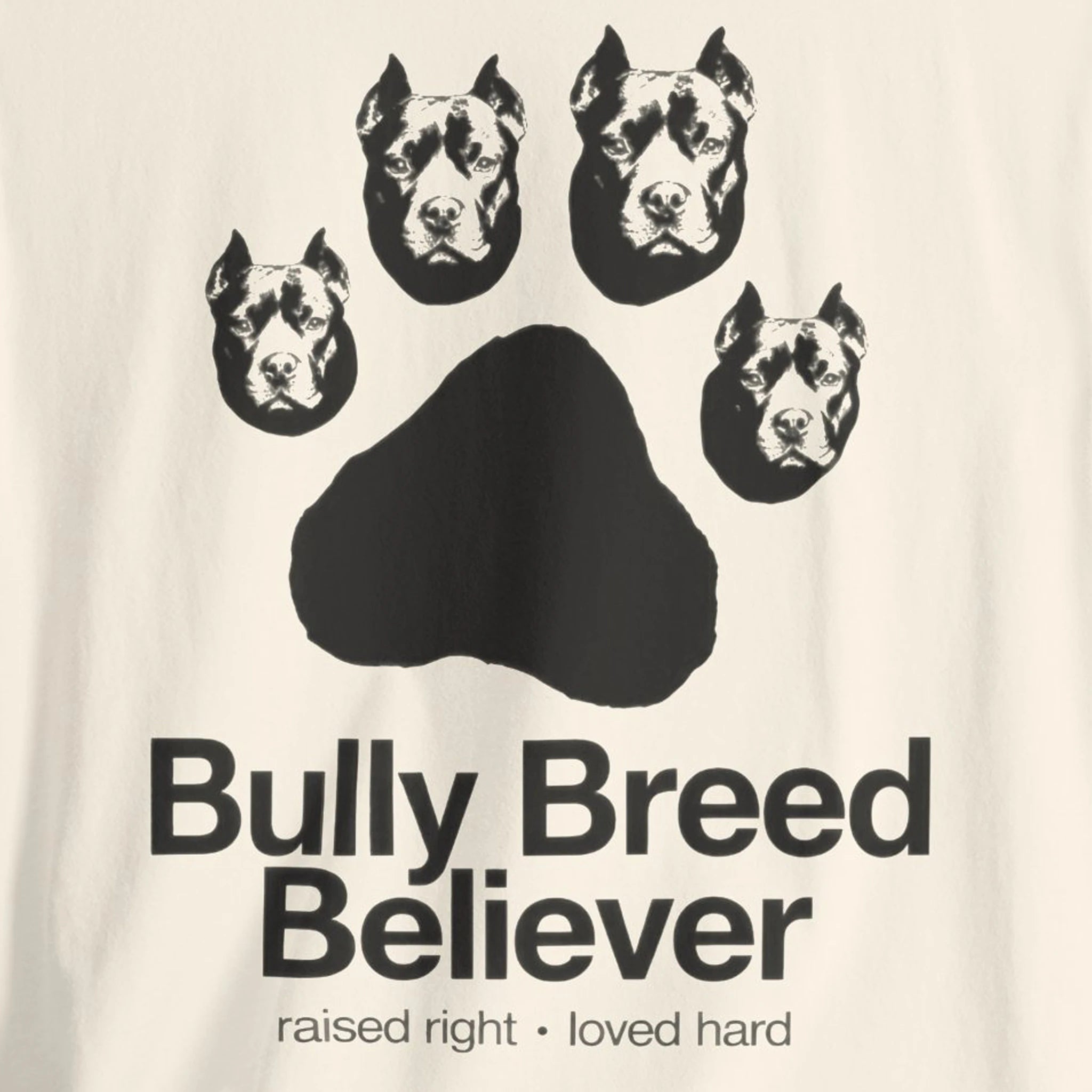 T-shirt with graphic of dog heads and text 'Bully Breed Believer' on a beige background