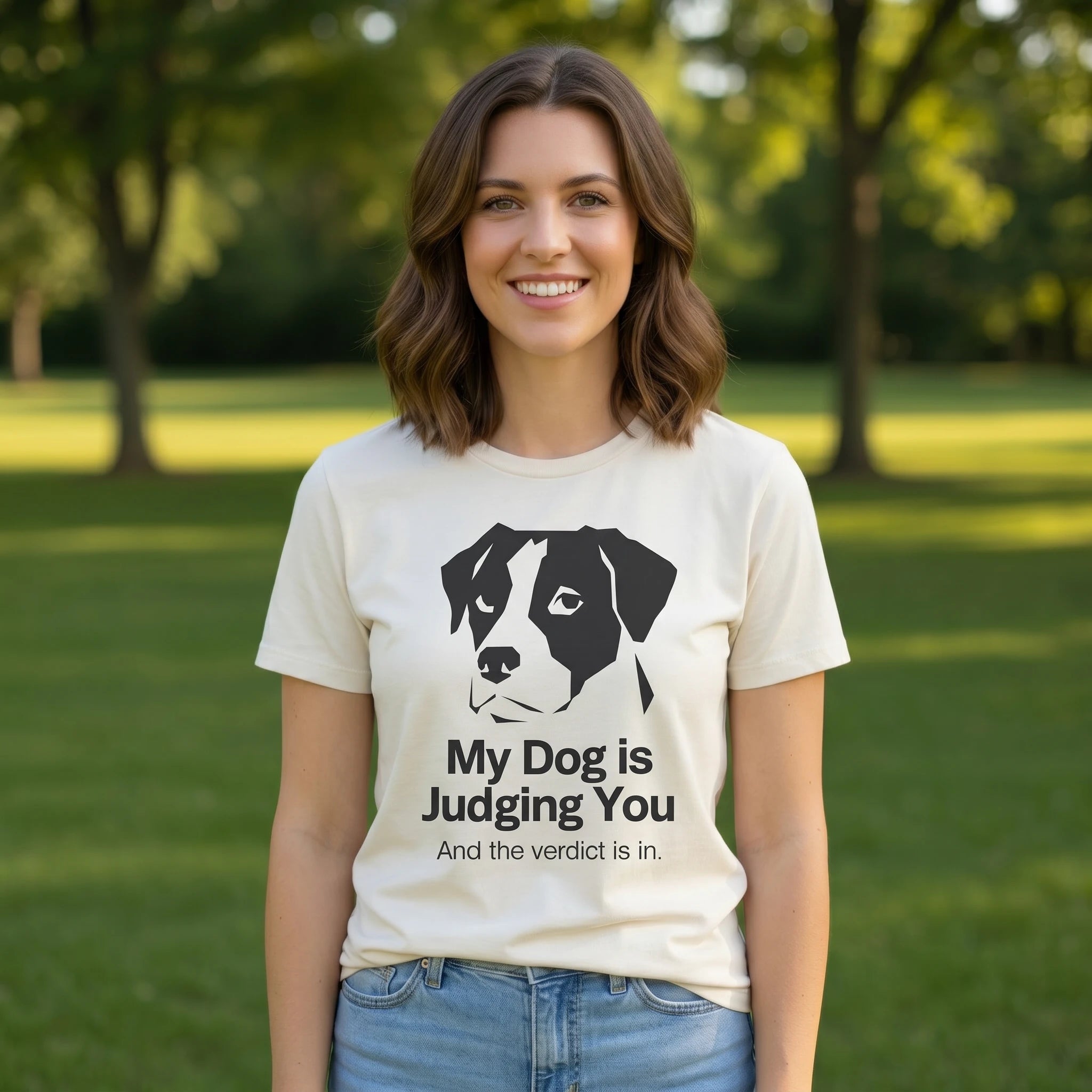 Woman wearing a t-shirt with a dog graphic and 'My Dog is Judging You' text in a park