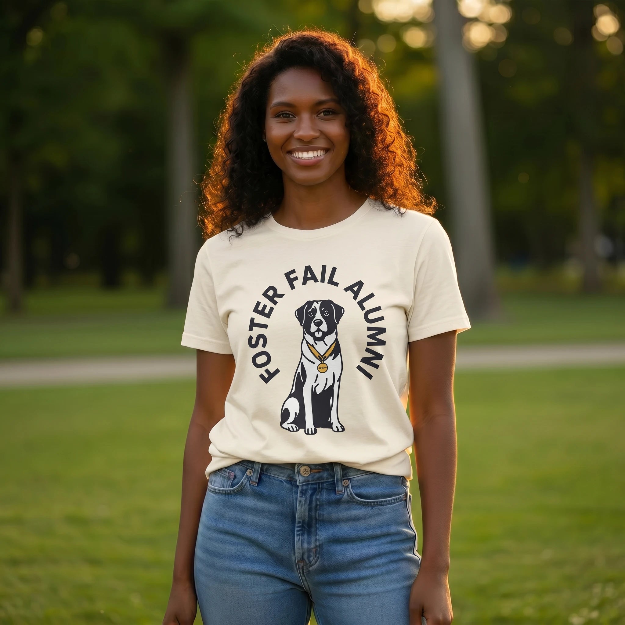 Woman wearing a t-shirt with a dog graphic and 'Foster Fail Alumni' text in a park