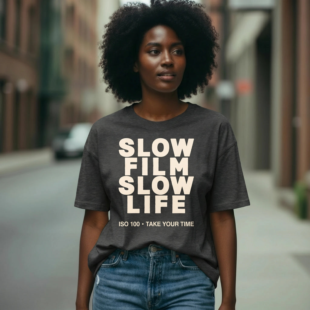 Woman wearing a t-shirt with 'Slow Film Slow Life' text on a city street.