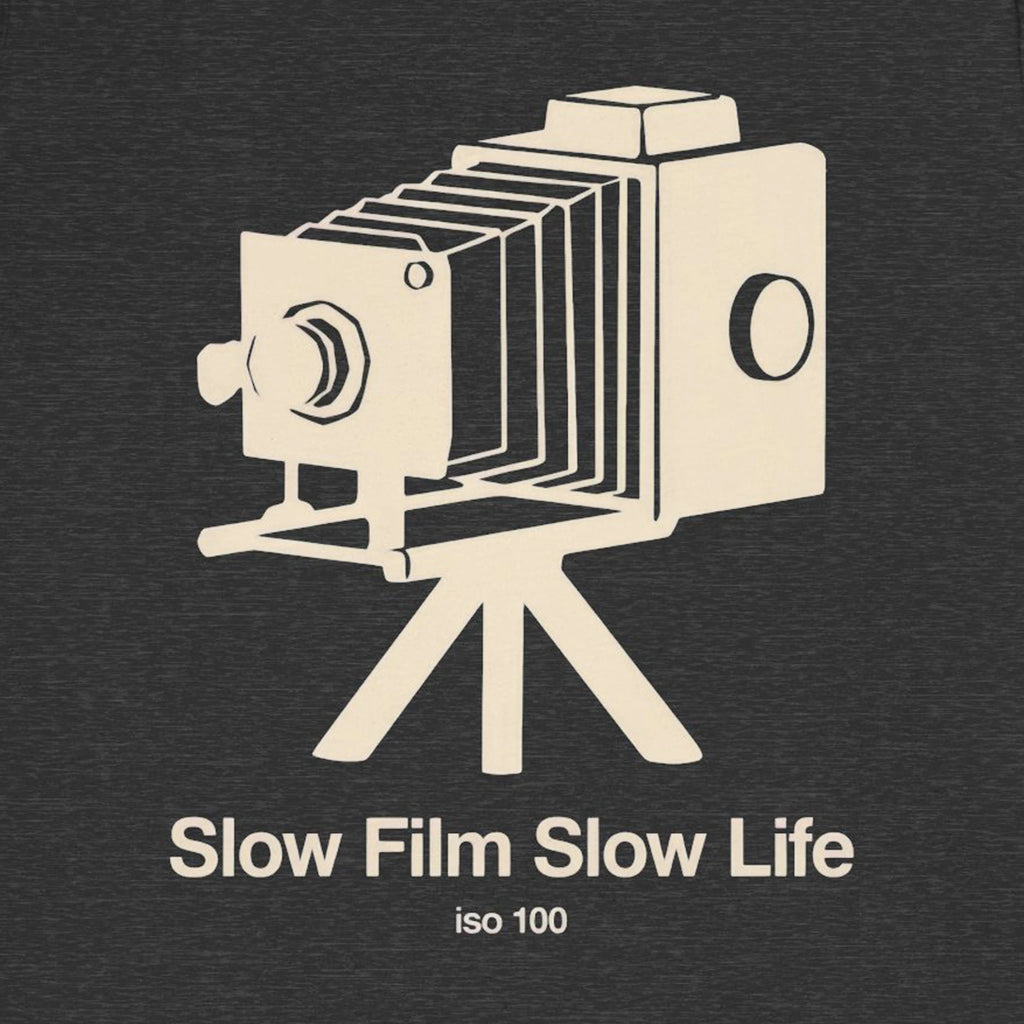 Vintage camera illustration with 'Slow Film Slow Life iso 100' text on a dark background
