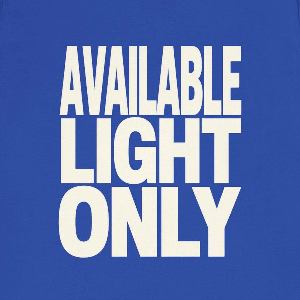 Blue shirt with 'AVAILABLE LIGHT ONLY' text in white