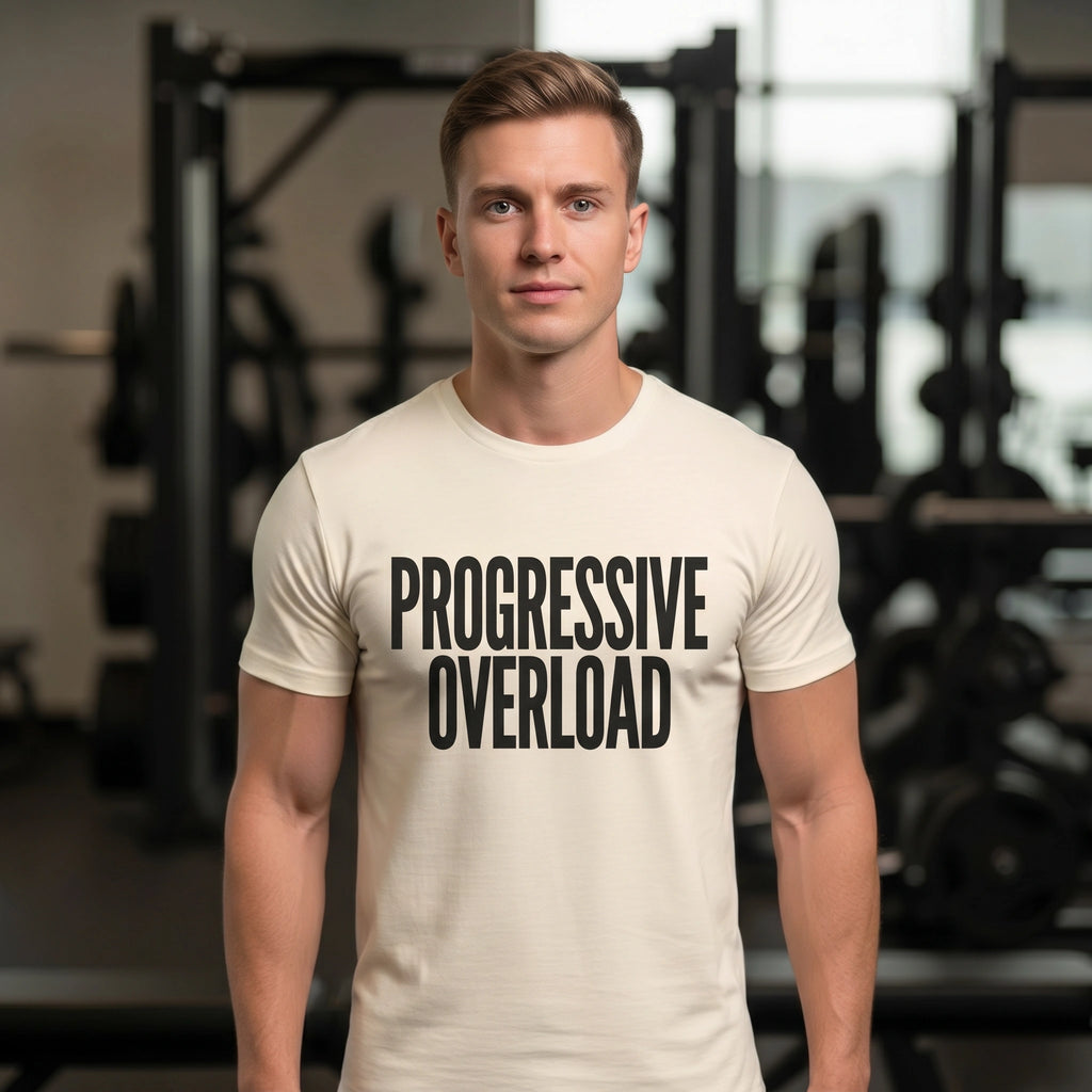 Man wearing a t-shirt with 'PROGRESSIVE OVERLOAD' in a gym setting