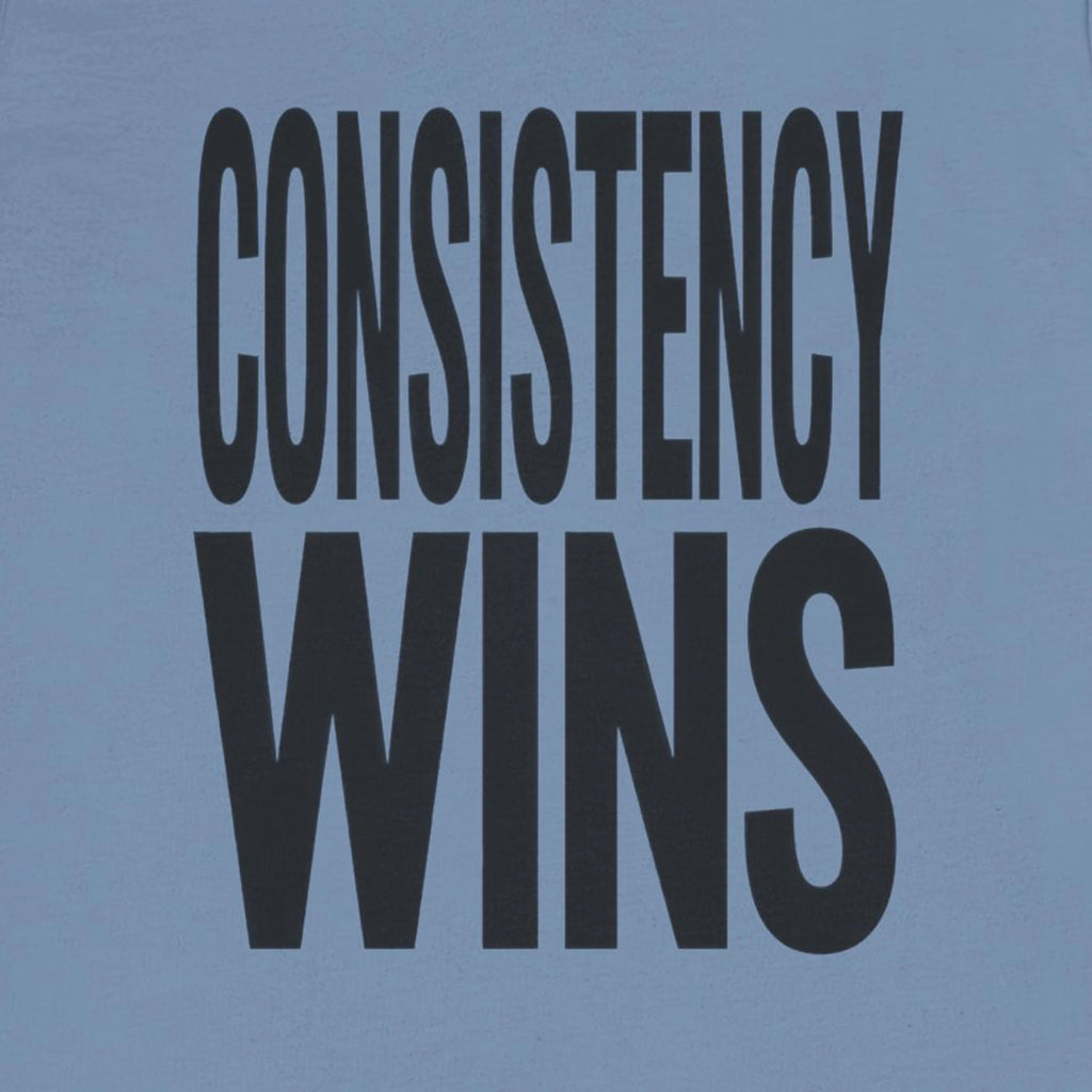 Blue t-shirt with 'CONSISTENCY WINS' text in black on a solid background