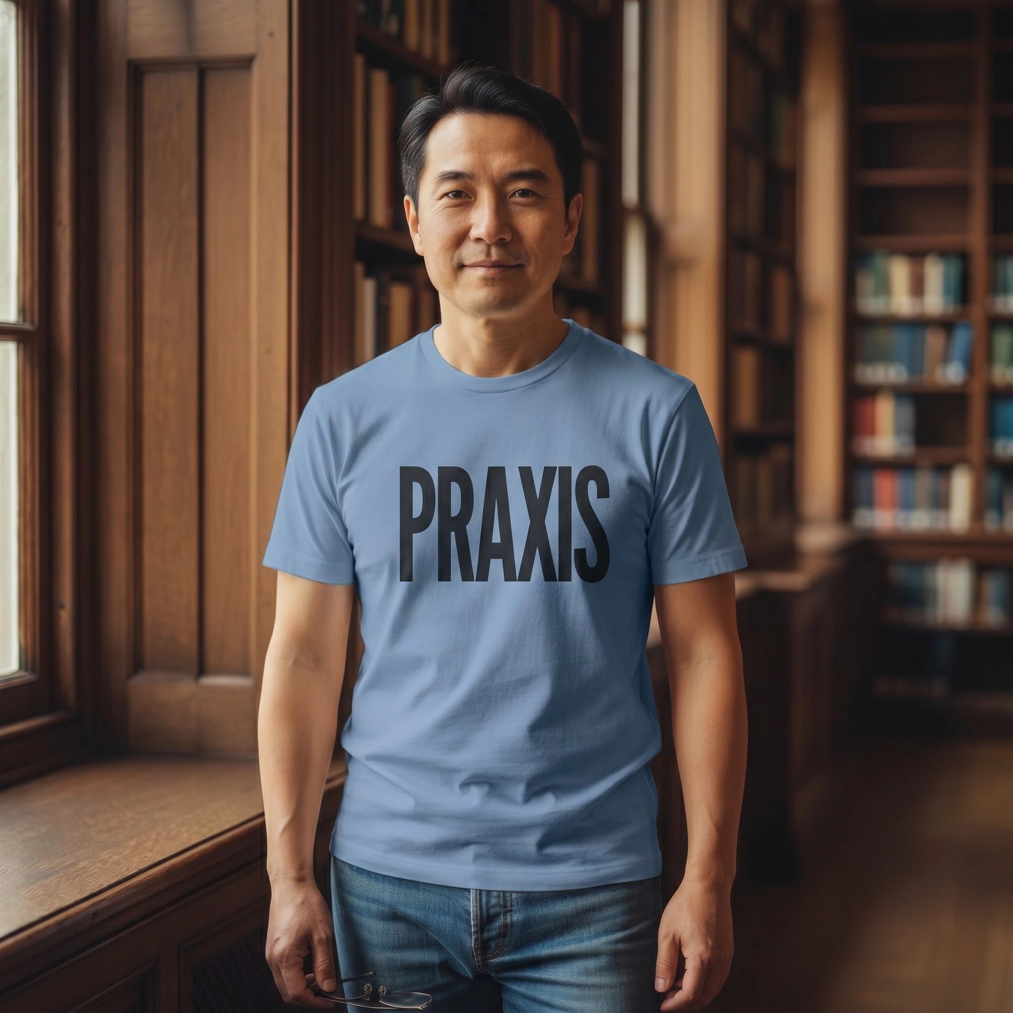 Man wearing a blue 'PRAXIS' t-shirt in a library setting