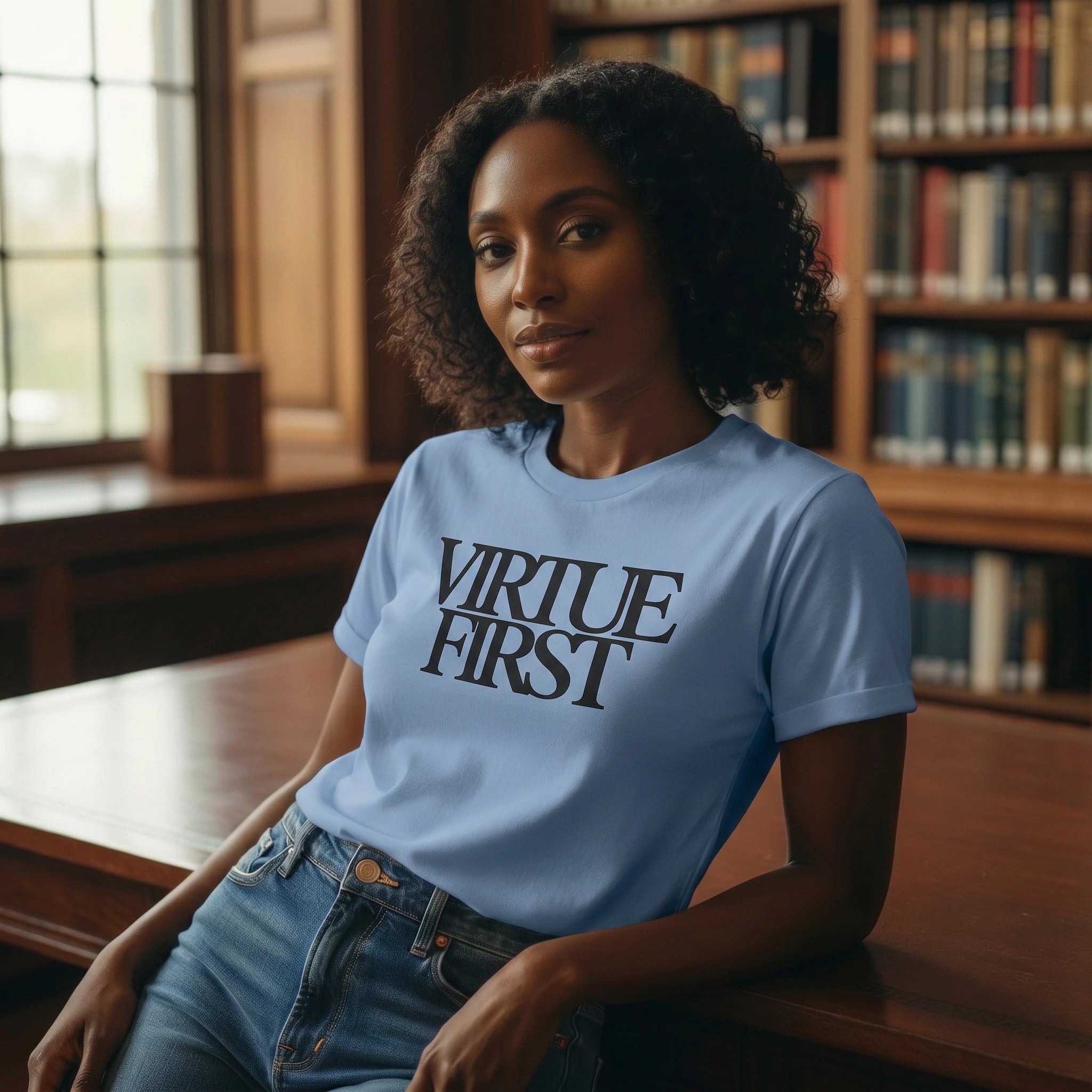 Woman wearing a blue t-shirt with 'Virtue First' text in a library setting