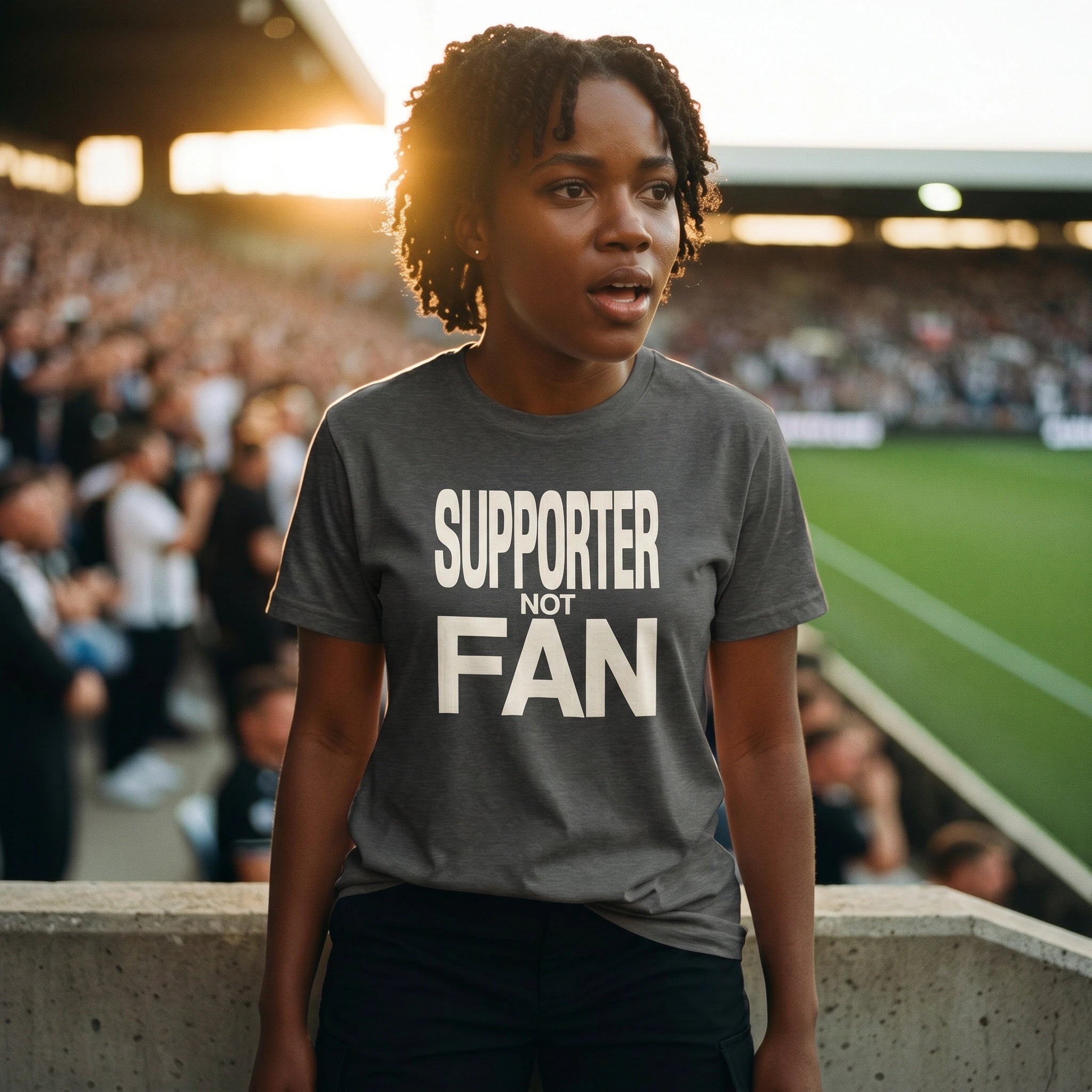 Person wearing a 'SUPPORTER NOT FAN' t-shirt at a sports event.