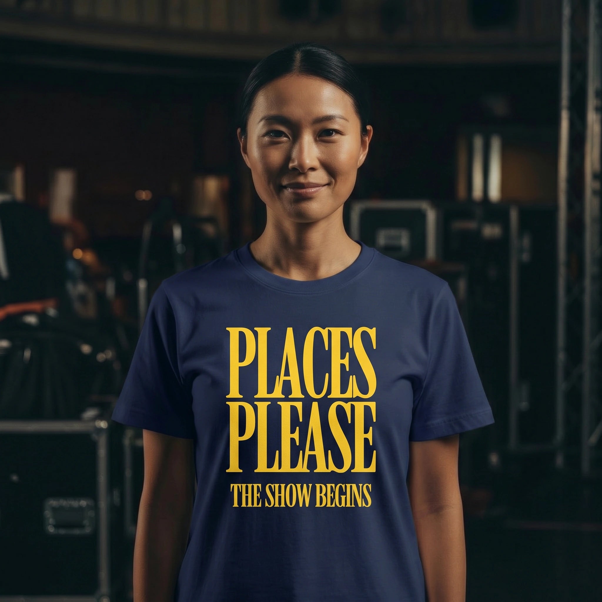 Person wearing a blue t-shirt with yellow text in a dark indoor setting