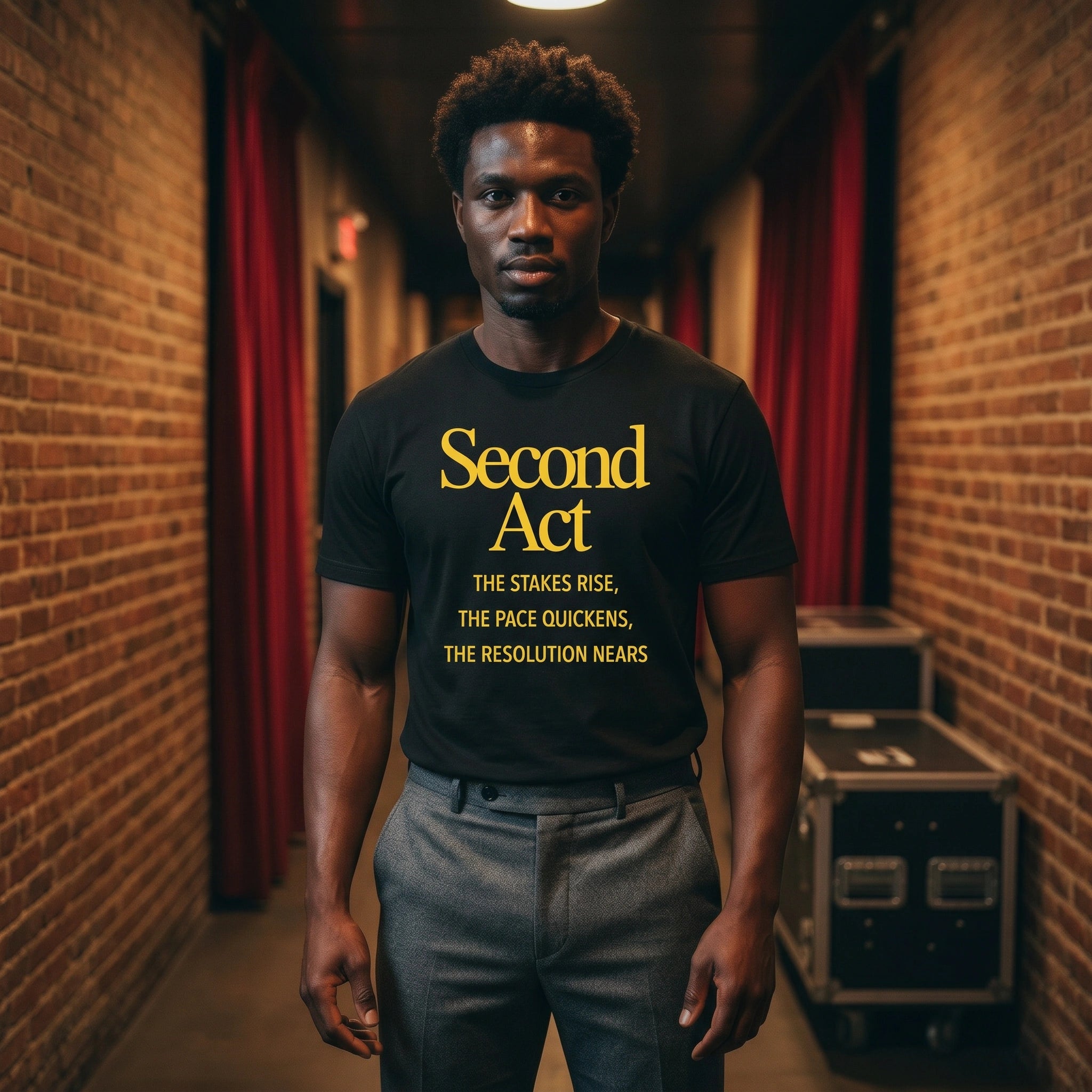 Man wearing a black t-shirt with 'Second Act' text in a theater setting