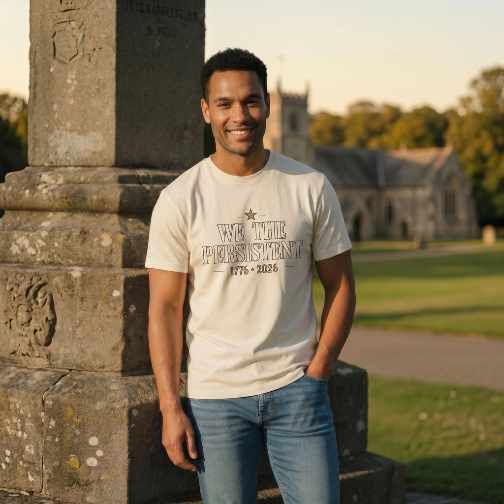 Man wearing a t-shirt with 'We the Persistent' text standing next to a stone monument.