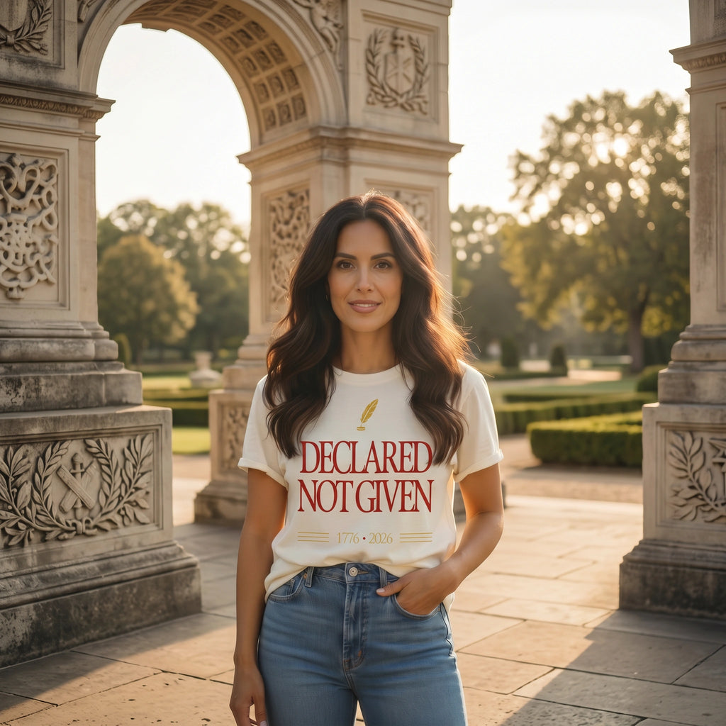 Woman wearing a t-shirt with text standing in front of an architectural archway.