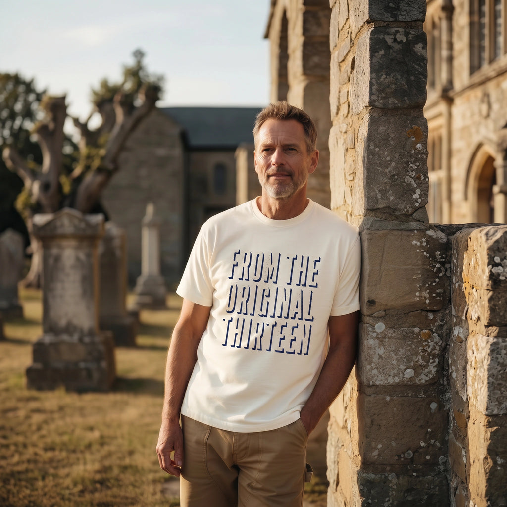 Man wearing a white t-shirt with text standing in a cemetery.