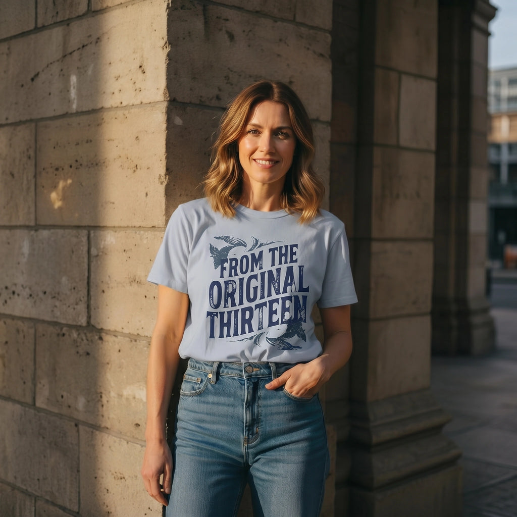 Woman wearing a t-shirt with text standing against a stone wall.