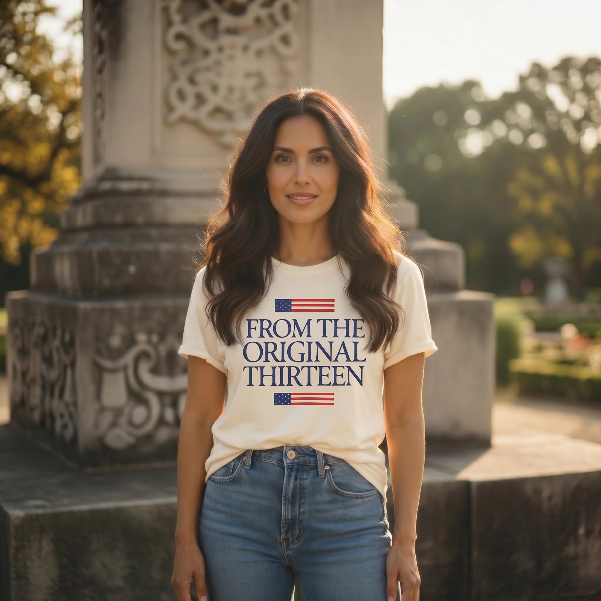 Woman wearing a white t-shirt with text and an American flag design, standing outdoors.